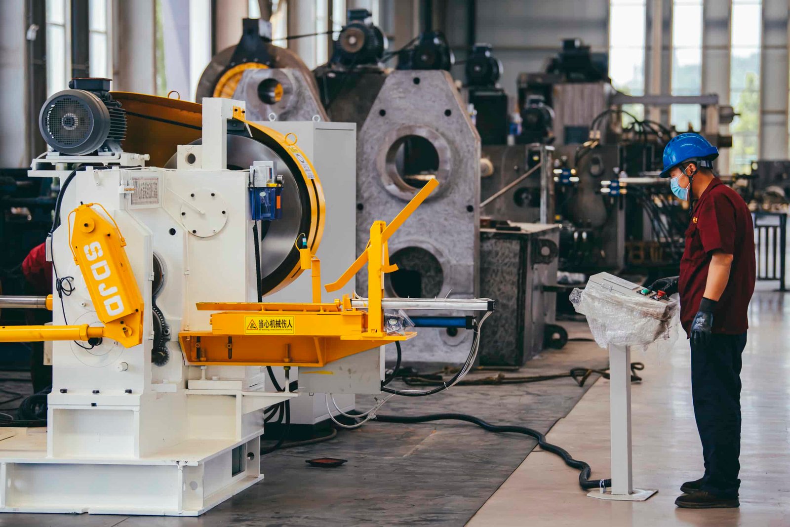 the worker is testing and make trial running of a new reduce roller roll forging machine